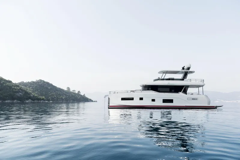  Yacht Photos Pics 2026 Sirena 60 yacht on calm waters near a scenic coastline.