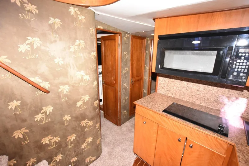 The Dog Patch Yacht Photos Pics Interior of 1990 Ocean Yachts 48 Super Sport with kitchen and palm-patterned walls.