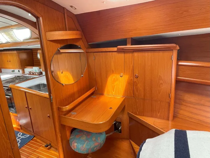 Sea Bear Yacht Photos Pics Interior of 1998 Jeanneau Sun Odyssey 45.2 yacht with wooden cabinetry and compact kitchen.