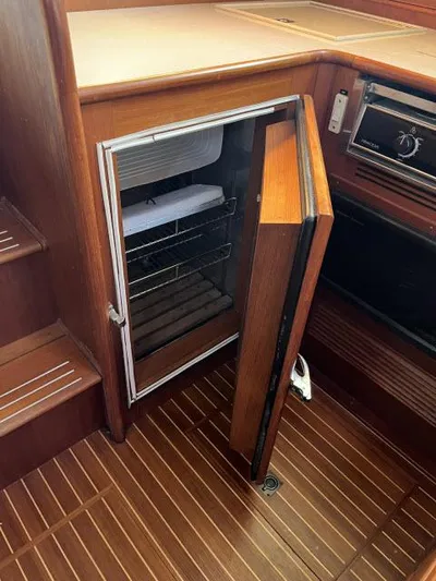 Lio Kai Yacht Photos Pics 1999 Grand Banks Eastbay 38 yacht interior with open wooden cabinet and refrigerator.
