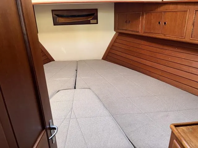 Lio Kai Yacht Photos Pics Interior cabin of 1999 Grand Banks Eastbay 38 with wooden paneling and bed.