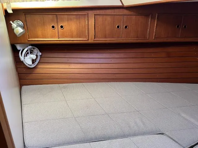 Lio Kai Yacht Photos Pics Cozy cabin interior of 1999 Grand Banks Eastbay 38 with wooden cabinets and bed.