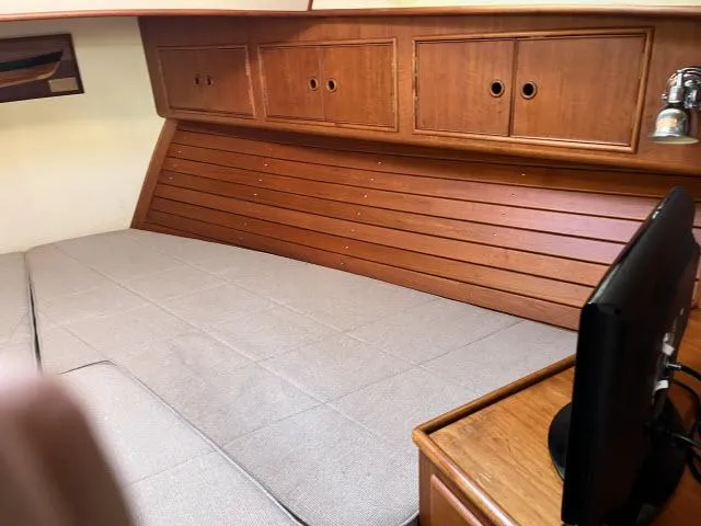 Lio Kai Yacht Photos Pics Cozy cabin interior of 1999 Grand Banks Eastbay 38 with wooden cabinetry and bed.