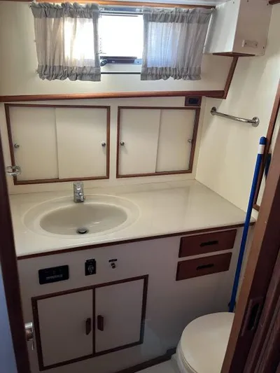 Lio Kai Yacht Photos Pics Bathroom interior of 1999 Grand Banks Eastbay 38 yacht with sink and storage cabinets.