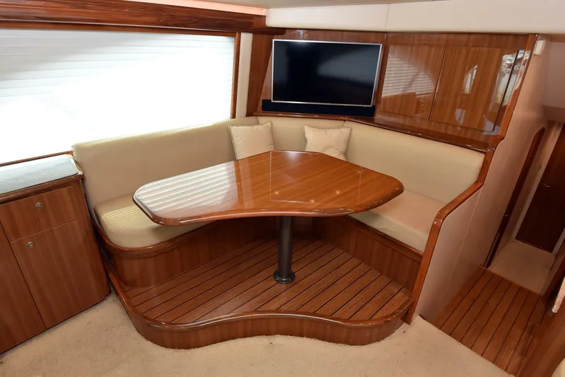 My Way Yacht Photos Pics Luxurious interior of 2019 Viking 44 Convertible yacht with wooden dining area and TV.