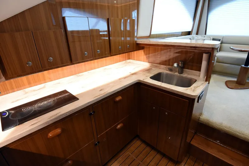 My Way Yacht Photos Pics Luxurious kitchen interior of 2019 Viking 44 Convertible yacht with wood cabinetry and modern amenities.