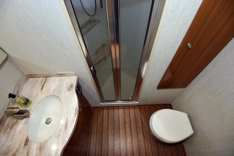 My Way Yacht Photos Pics Luxurious bathroom in 2019 Viking 44 Convertible yacht with wood flooring and modern fixtures.