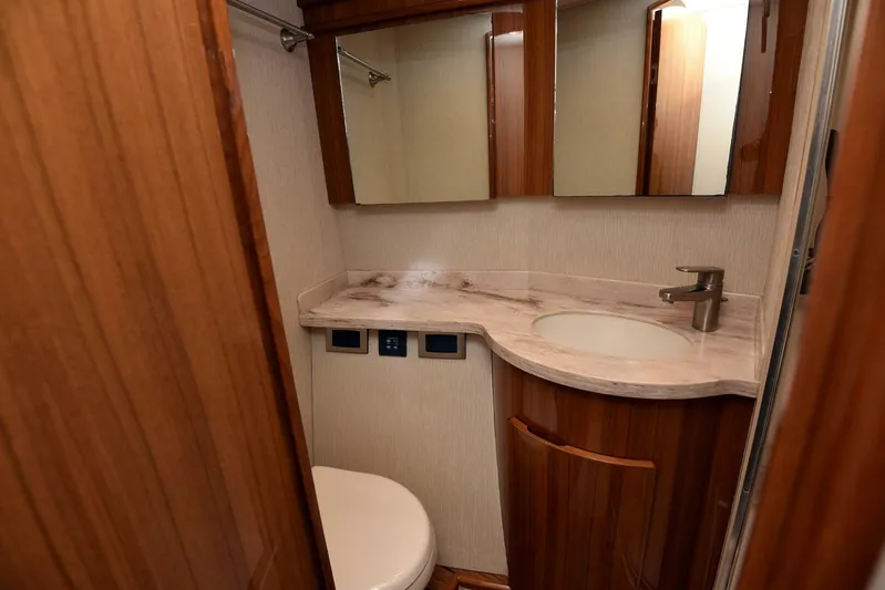 My Way Yacht Photos Pics Luxurious bathroom in 2019 Viking 44 Convertible yacht with wooden cabinetry and modern fixtures.