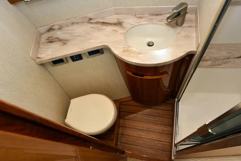 My Way Yacht Photos Pics Luxurious bathroom in 2019 Viking 44 Convertible yacht with modern fixtures and wood flooring.