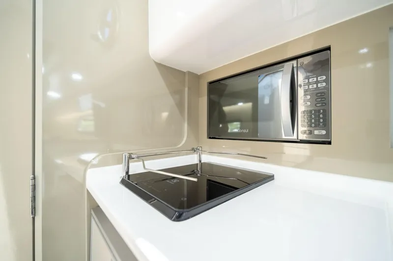  Yacht Photos Pics Modern kitchen area in 2025 Hanover 387 with microwave and sleek stovetop.