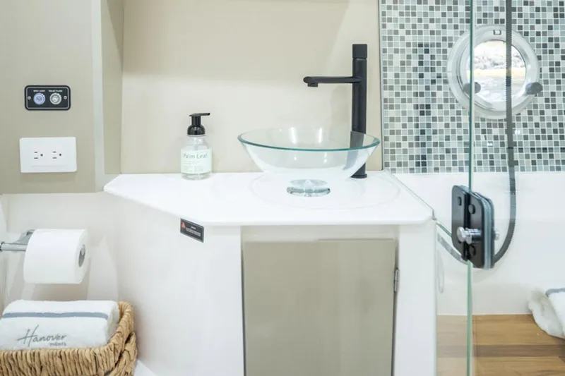  Yacht Photos Pics Modern bathroom in 2025 Hanover 387 RV with glass sink and mosaic tiles.