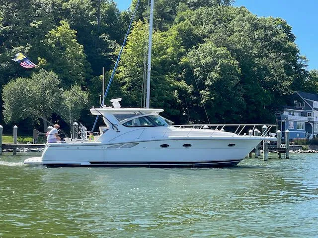  Yacht Photos Pics 2000 Tiara Yachts 38 Open cruising on a sunny day near a wooded shoreline.