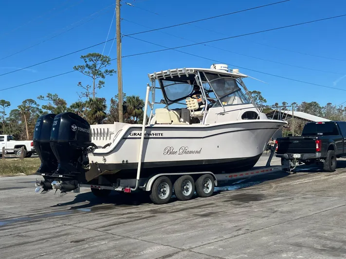  Yacht Photos Pics 2003 Grady-White Marlin 300 boat on trailer, parked outdoors, clear sky.