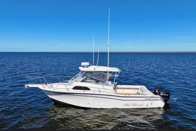  Yacht Photos Pics 2003 Grady-White Marlin 300 boat on open water under clear blue sky.