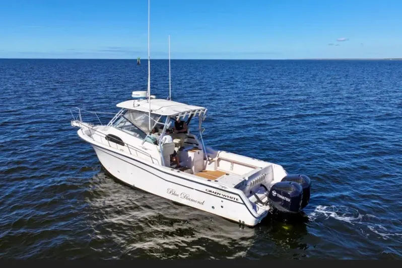  Yacht Photos Pics 2003 Grady-White Marlin 300 boat cruising on open water under clear blue sky.