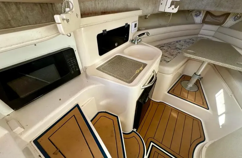  Yacht Photos Pics 2003 Grady-White Marlin 300 cabin interior with kitchenette, sink, and seating area.