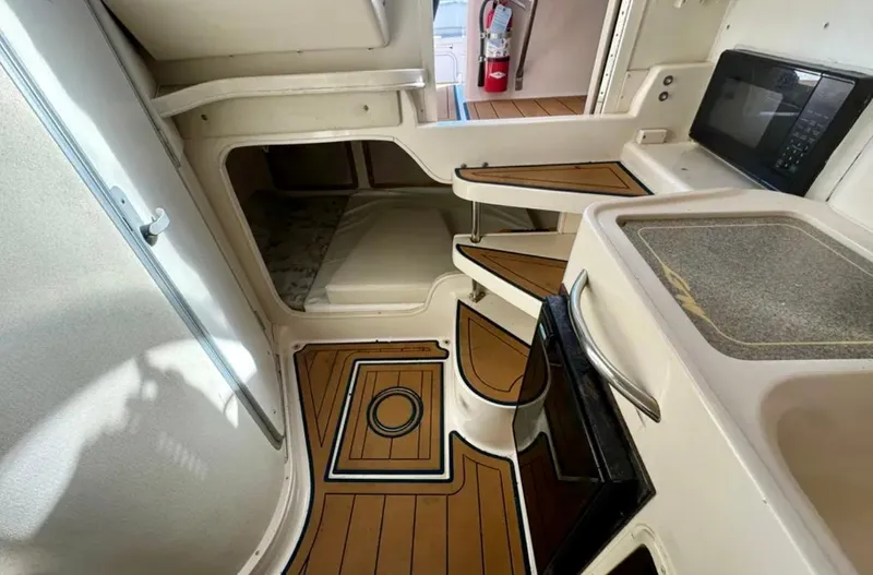  Yacht Photos Pics 2003 Grady-White Marlin 300 cabin interior with wood flooring, kitchenette, and compact design.