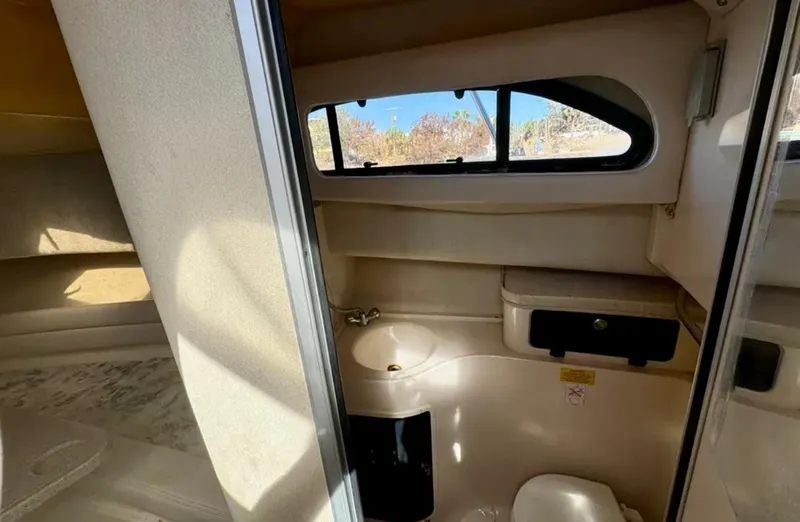  Yacht Photos Pics 2003 Grady-White Marlin 300 cabin interior with compact bathroom and window view.