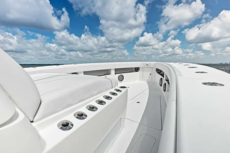 Fish Wish Yacht Photos Pics 2023 SeaVee 450z boat deck with seating, under a partly cloudy sky.