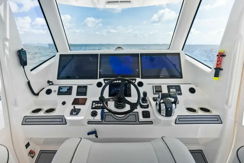 Fish Wish Yacht Photos Pics 2023 SeaVee 450z helm with advanced navigation displays and controls, overlooking the ocean.
