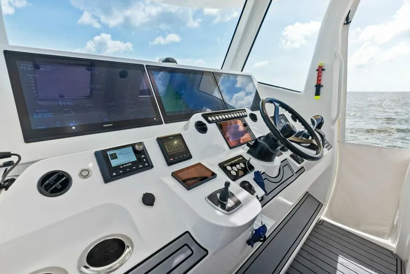 Fish Wish Yacht Photos Pics 2023 SeaVee 450z helm with advanced navigation displays and controls, ocean view.
