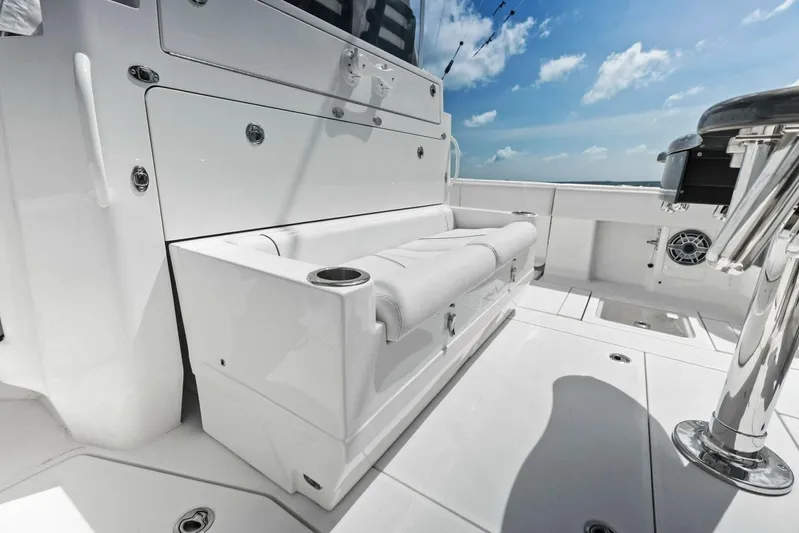 Fish Wish Yacht Photos Pics 2023 SeaVee 450z boat interior with white seating and stainless steel fixtures under a blue sky.