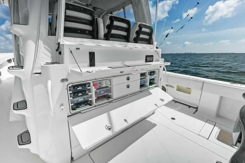 Fish Wish Yacht Photos Pics 2023 SeaVee 450z boat interior with storage compartments, ocean view, and fishing rods.