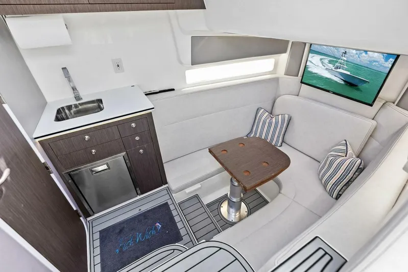 Fish Wish Yacht Photos Pics Luxurious interior of 2023 SeaVee 450z boat with kitchenette and seating area.