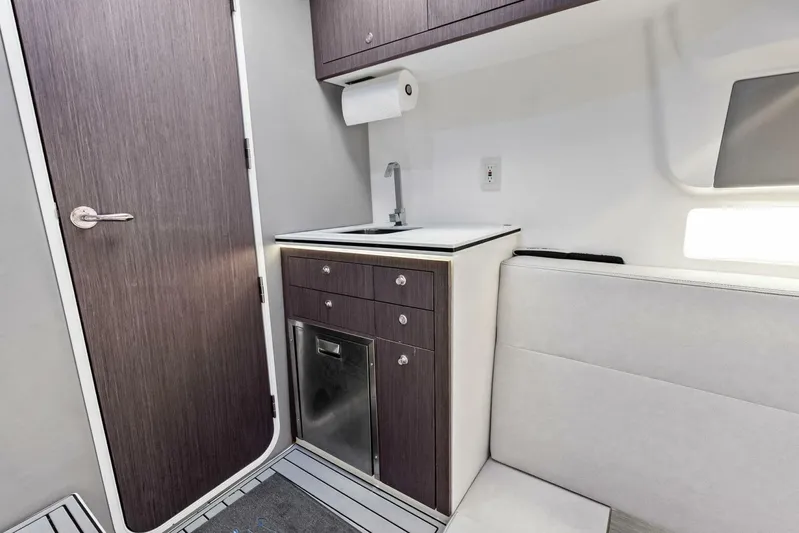 Fish Wish Yacht Photos Pics 2023 SeaVee 450z interior with sink, cabinetry, and seating area.