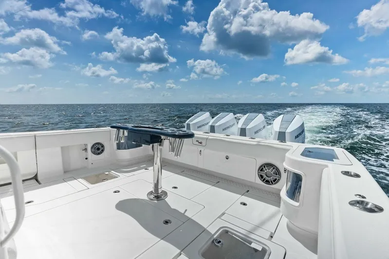 Fish Wish Yacht Photos Pics 2023 SeaVee 450z boat with multiple engines cruising on open water under a blue sky.