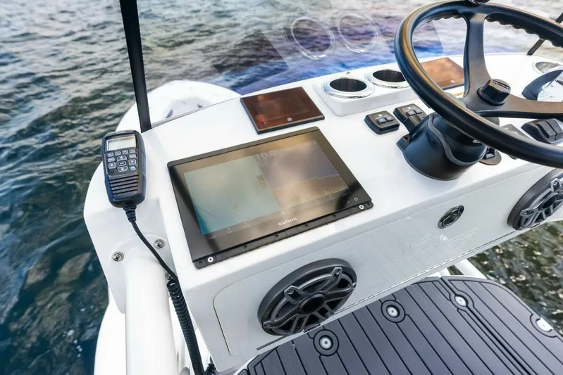 Fish Wish Yacht Photos Pics 2023 SeaVee 450z boat dashboard with navigation equipment and steering wheel on open water.