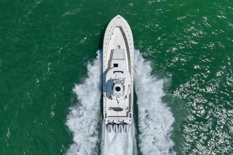Fish Wish Yacht Photos Pics Aerial view of 2023 SeaVee 450z boat cruising on vibrant green water.
