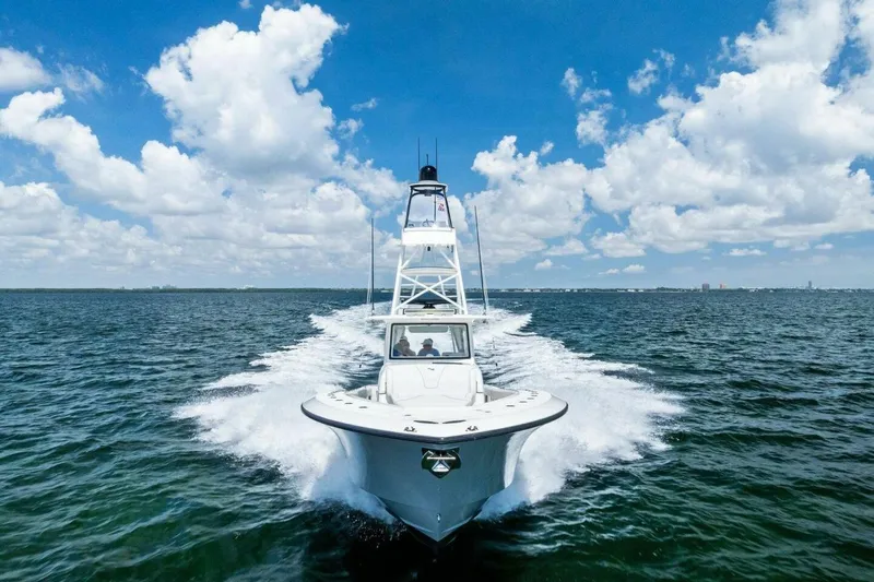 Fish Wish Yacht Photos Pics 2023 SeaVee 450z boat cruising on open water under a bright blue sky.