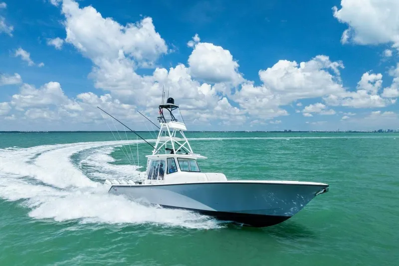 Fish Wish Yacht Photos Pics 2023 SeaVee 450z boat cruising on turquoise water under a clear blue sky.