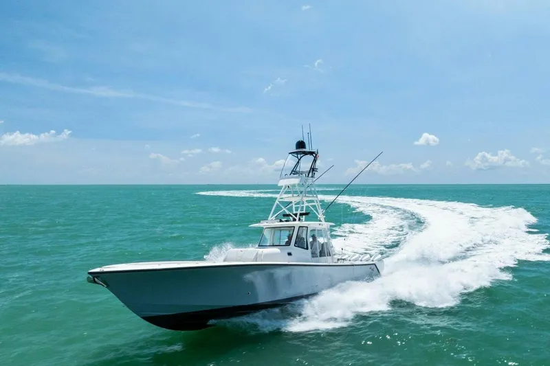 Fish Wish Yacht Photos Pics 2023 SeaVee 450z boat cruising on turquoise ocean under clear blue sky.