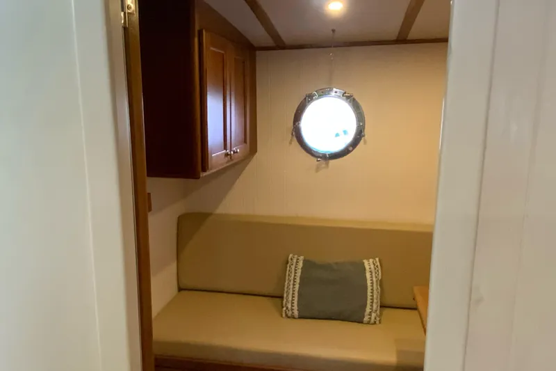 Lone Star (former/recently Andros) Yacht Photos Pics Cozy interior of 2008 Great Harbour N37 boat with porthole and cushioned seating.