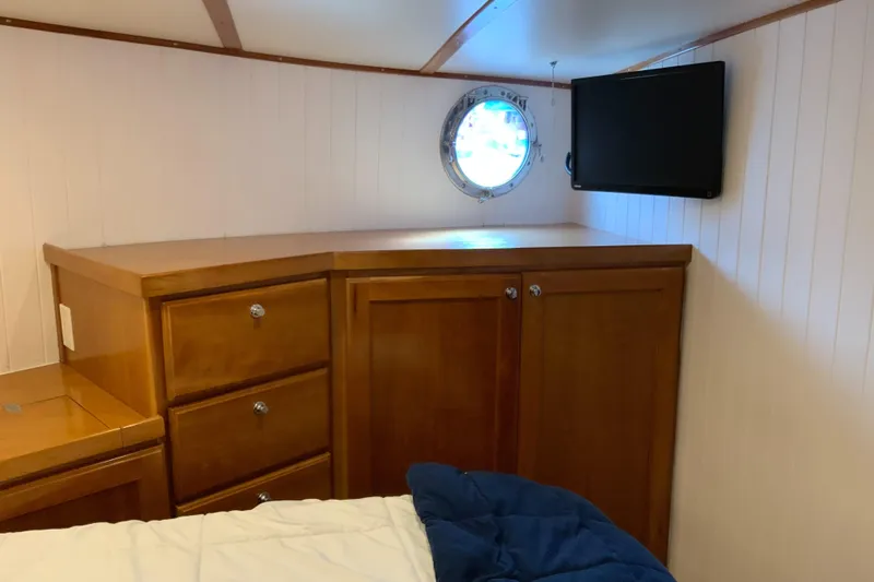 Lone Star (former/recently Andros) Yacht Photos Pics 2008 Great Harbour N37 cabin interior with wooden cabinets, porthole, and wall-mounted TV.