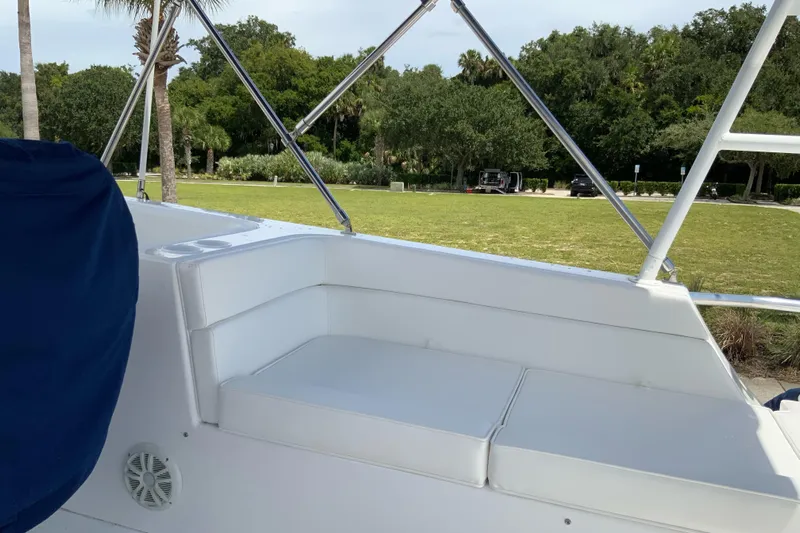 Lone Star (former/recently Andros) Yacht Photos Pics 2008 Great Harbour N37 boat with white seating and blue cover, docked near a grassy area.