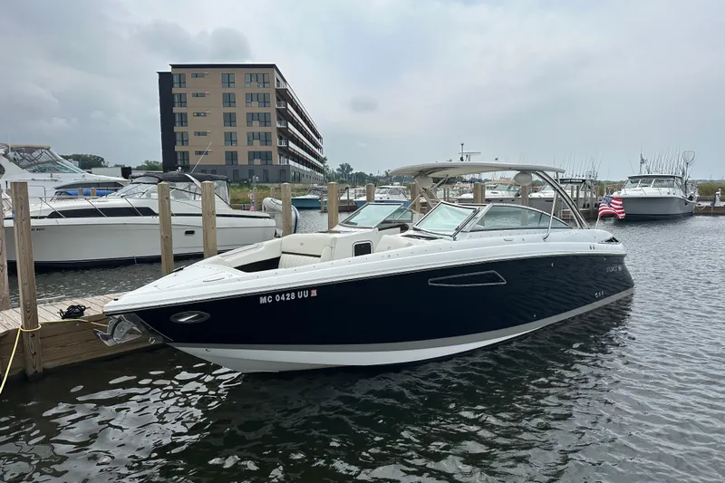  Yacht Photos Pics 2015 Cobalt 336 boat docked at marina, modern building in background, American flag visible.
