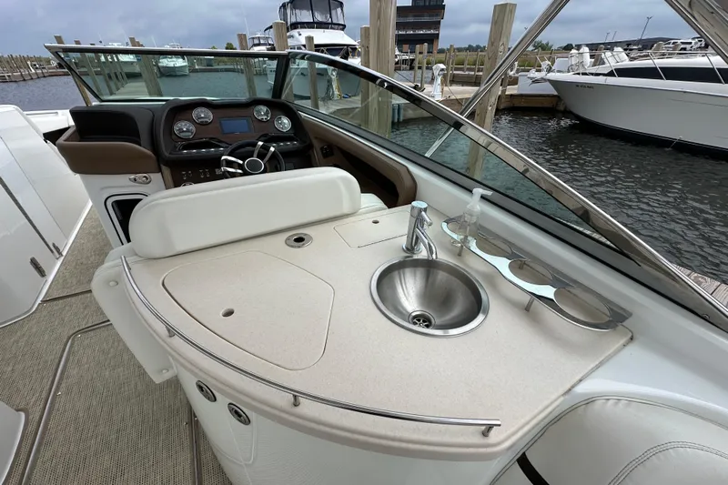  Yacht Photos Pics 2015 Cobalt 336 boat interior with helm, sink, and seating at marina.