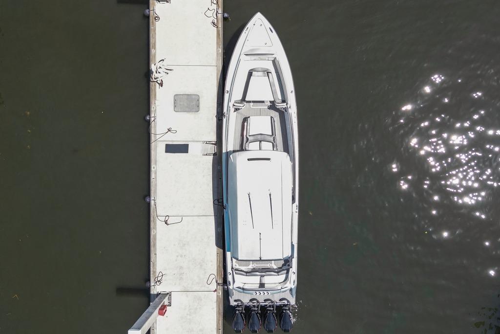 Overhead view of 2021 Nor-Tech 390 Sport Center Console docked on calm water.