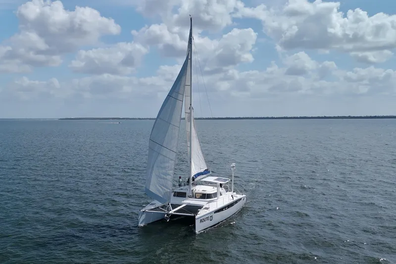 Route 66 Yacht Photos Pics 2005 Dolphin 460 Sail Catamaran sailing on open water under a partly cloudy sky.