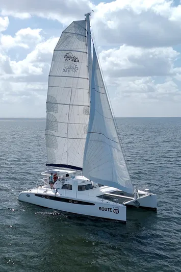Route 66 Yacht Photos Pics 2005 Dolphin 460 Sail Catamaran cruising on open water under a cloudy sky.