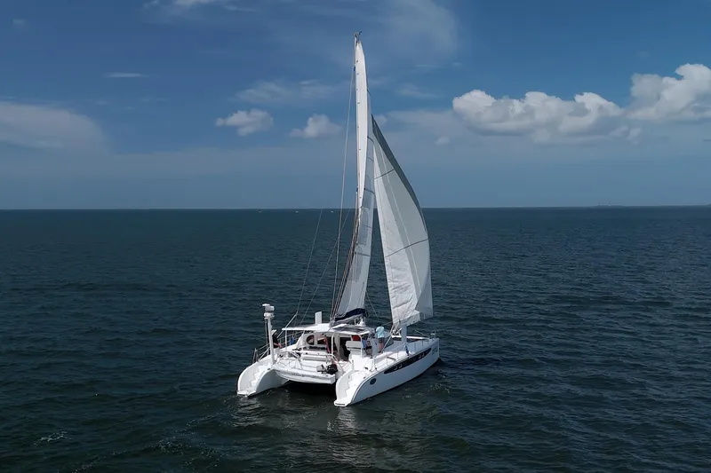 Route 66 Yacht Photos Pics Sailing catamaran Dolphin 460 on open sea under clear blue sky.