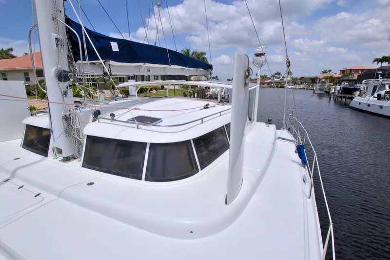 Route 66 Yacht Photos Pics 2005 Dolphin 460 Sail Catamaran docked in a marina under a partly cloudy sky.