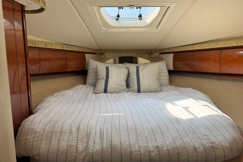 Grand Bleu Yacht Photos Pics Luxurious cabin interior of 2003 Sea Ray 420 Sundancer yacht with skylight and striped bedding.