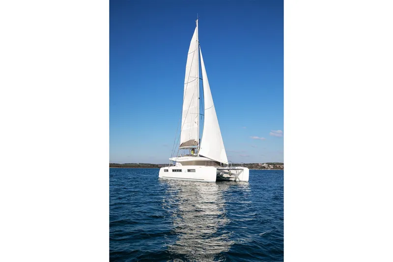 Aliana Yacht Photos Pics 2022 Lagoon 50 catamaran sailing on calm blue waters under clear sky.
