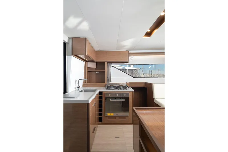 Aliana Yacht Photos Pics Modern kitchen interior of 2022 Lagoon 50 yacht with wood cabinetry and appliances.