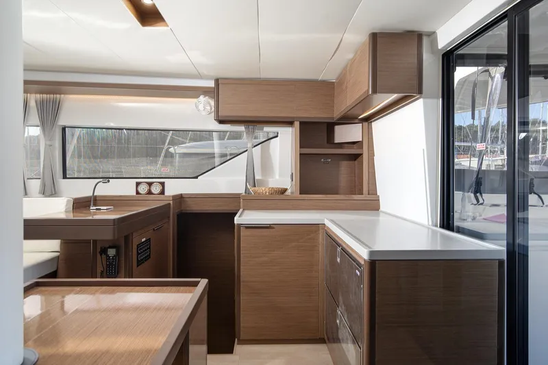 Aliana Yacht Photos Pics Modern interior of 2022 Lagoon 50 yacht with sleek wooden cabinetry and large windows.