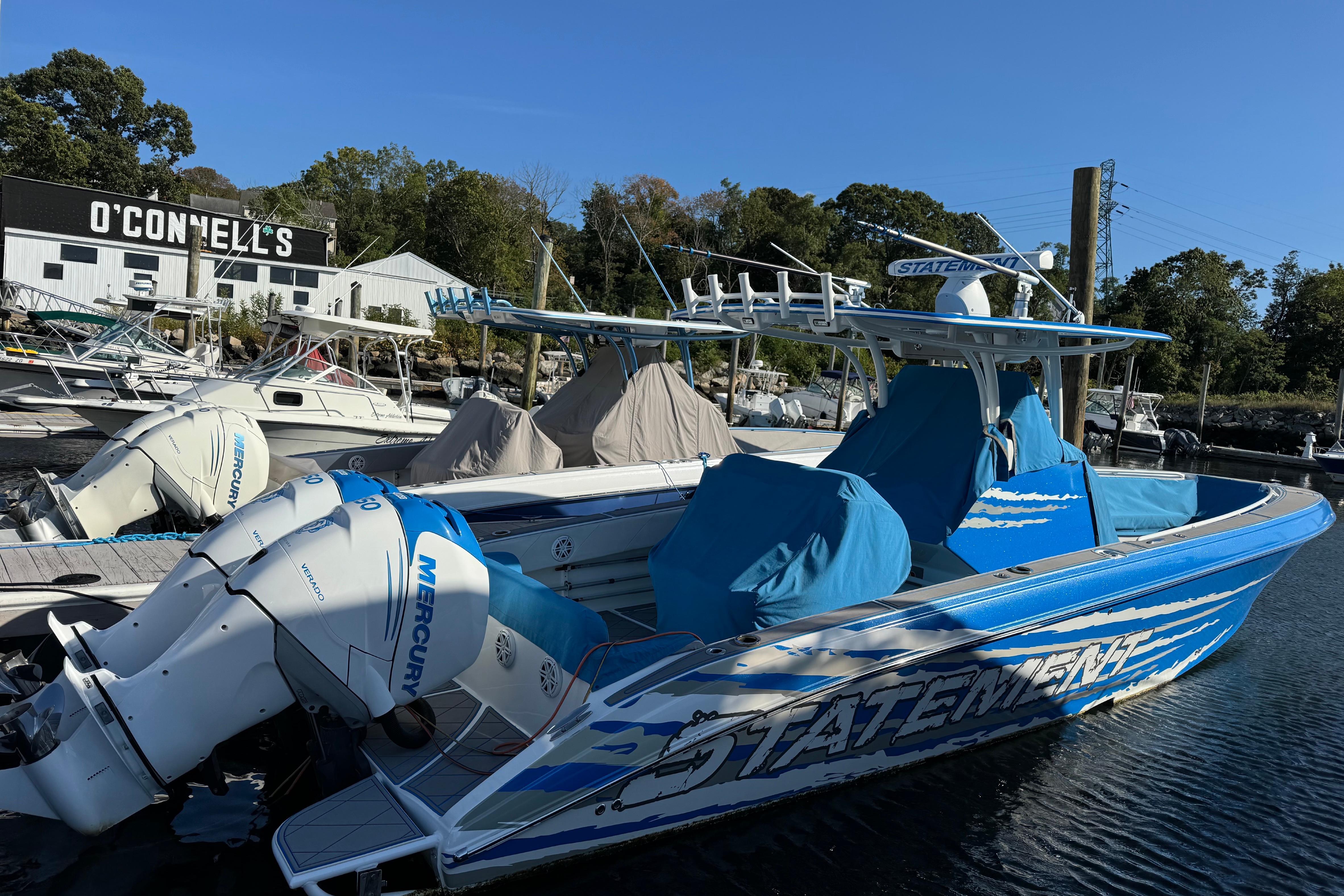 Blue 2016 Statement 350 Open boat docked with Mercury engines at marina.